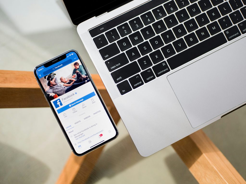 Facebook Stellenanzeigen Smartphone liegt neben Laptop