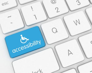 Tastatur mit hervorgehobener blauer Taste, auf der ein Rollstuhlsymbol und das Wort „accessibility“ (Barrierefreiheit) zu sehen sind – Symbolbild für digitale Barrierefreiheit.
