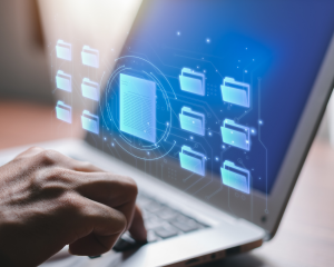 Hand tippt auf Laptop-Tastatur, während digitale Ordner- und Dokumentensymbole auf dem Bildschirm schweben – symbolisiert digitales Bewerbermanagement oder Datenorganisation.